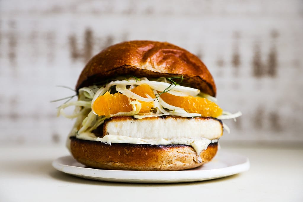A grilled swordfish sandwich piled high with shaved fennel and orange salad.