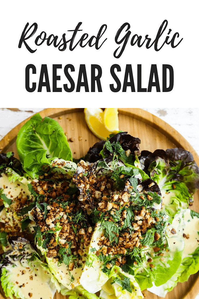 A Caesar salad on a wood plate on a wood surface.